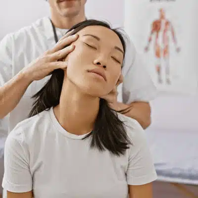 Chiropractor performs gentle cervical adjustment while patient relaxes seated, improving mobility, easing chronic discomfort symptoms
