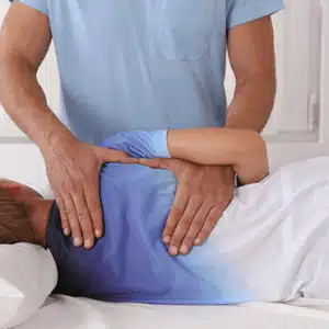 Scoliosis chiropractor adjusts patient’s spine while lying on side to correct curvature and relieve discomfort