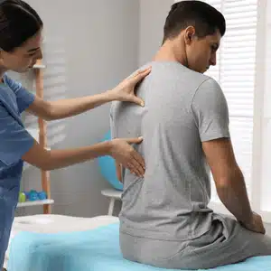 Scoliosis chiropractor applies pressure to mid-back area to relieve tension and realign spinal curvature
