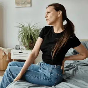 A woman sits up in pain