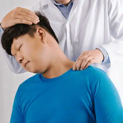 Chiropractor treating man’s neck to reduce stiffness and pain, a chiropractor for rheumatoid arthritis
