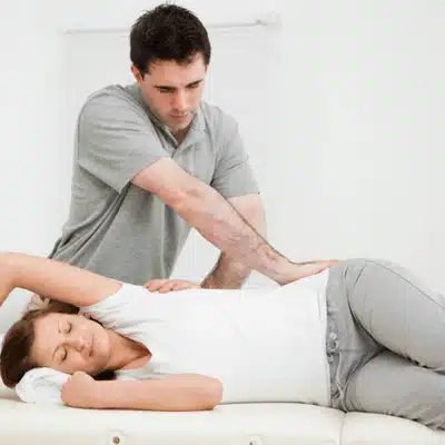 Chiropractor performs gentle side-lying lumbar adjustment as relaxed patient breathes steadily during treatment for alignment