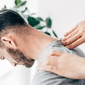 Professional applying therapeutic touch, showing a technique used in chiropractic for neck pain