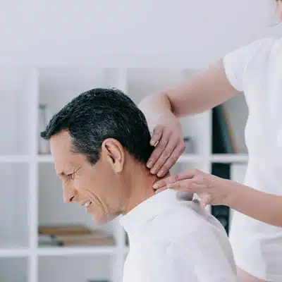 Clinician applies manual therapy to man's neck and shoulders, relieving tension, pain, and stiffness today